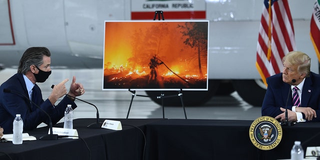 Then-President Trump, right, speaks with California Gov. Gavin Newsom at Sacramento McClellan Airport in McClellan Park, California, during a briefing on wildfires, Sept. 14, 2020.
