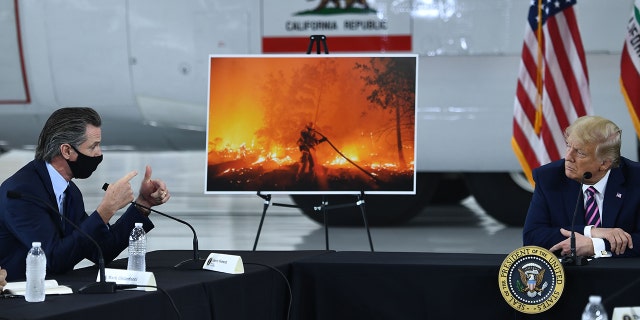Then-President Trump, right, speaks with California Gov. Gavin Newsom at Sacramento McClellan Airport in McClellan Park, California, during a briefing on wildfires, Sept. 14, 2020.
