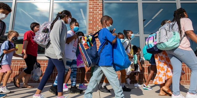 Students prepare to enter the building of Stratford Landing Elementary School in Alexandria, Virginia, on Monday, Aug. 23, 2021, the first day back to school for many districts in northern Virginia. (Amanda Andrade-Rhoades/For The Washington Post via Getty Images)