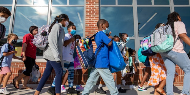 Students prepare to enter the building of Stratford Landing Elementary School in Alexandria, Virginia, on Monday, Aug. 23, 2021, the first day back to school for many districts in northern Virginia. (Amanda Andrade-Rhoades/For The Washington Post via Getty Images)