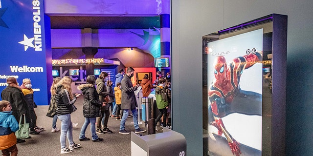 People entering a movie theater in Antwerp, Belgium, Friday, Dec. 24, 2021. 