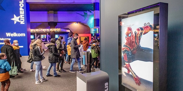 People entering a movie theater in Antwerp, Belgium, Friday, Dec. 24, 2021. 