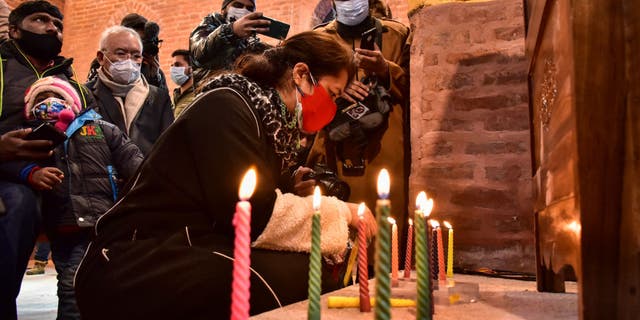 A Christian devotee lights candles inside St. Luke's Church on Christmas Day 2021 in Srinagar, India. (Saqib Majeed/SOPA Images/LightRocket via Getty Images)