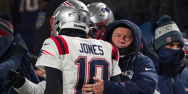 New England Patriots head coach Bill Belichick hugs quarterback Mac Jones.