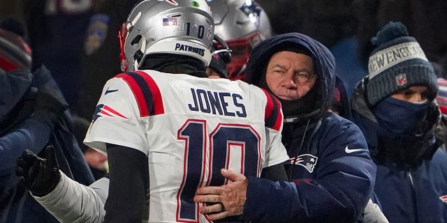 New England Patriots head coach Bill Belichick hugs quarterback Mac Jones.