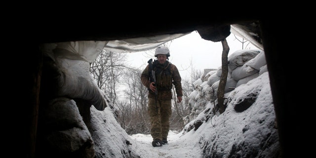 Ukrainian Military Forces serviceman walks along a snow covered trench in the eastern Lugansk region, on January 21, 2022. -