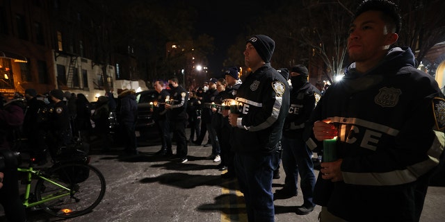 Hundreds of New York City police officers and firefighters gather Saturday at the 32nd Precinct in Harlem for a vigil honoring two officers who were shot in Harlem on Friday night. One police officer died, the other was critically wounded.