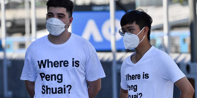Australian human rights campaigner Drew Pavlou (L) is pictured wearing a "Where is Peng Shuai?" T-shirt, referring to the former doubles world number one from China, on the grounds outside one of the venues on day nine of the Australian Open tennis tournament in Melbourne on Jan. 25, 2022.