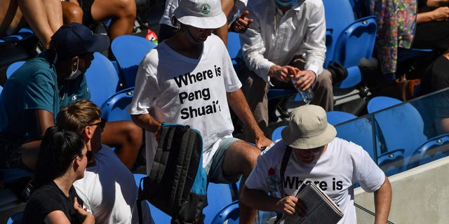 Two spectators wearing "[object Window]?" 郡刑務所での日数, referring to the former doubles world number one from China, are pictured in the stands on day nine of the Australian Open tennis tournament in Melbourne on Jan. 25, 2022.
