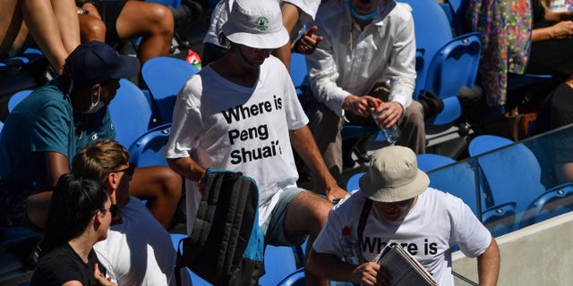 Two spectators wearing "Where is Peng Shuai?" T-shirts, referring to the former doubles world number one from China, are pictured in the stands on day nine of the Australian Open tennis tournament in Melbourne on Jan. 25, 2022.