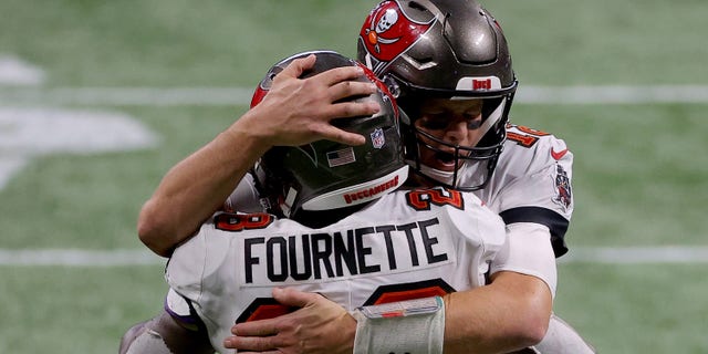 Tom Brady #12 of the Tampa Bay Buccaneers celebrates with Leonard Fournette #28 after a first down against the Atlanta Falcons during the fourth quarter in the game at Mercedes-Benz Stadium on December 20, 2020 in Atlanta, Georgia.