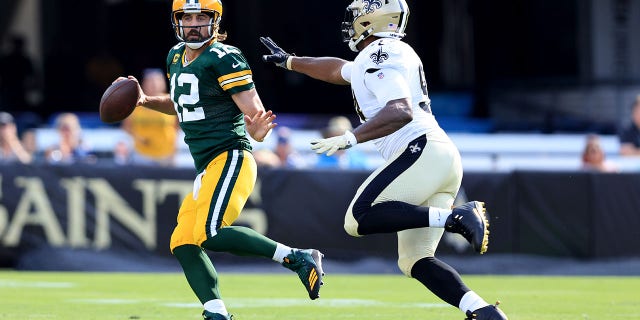 Aaron Rodgers of the Green Bay Packers scrambles against Cameron Jordan of the New Orleans Saints during the game at TIAA Bank Field on Sept. 12, 2021, in Jacksonville, Florida.