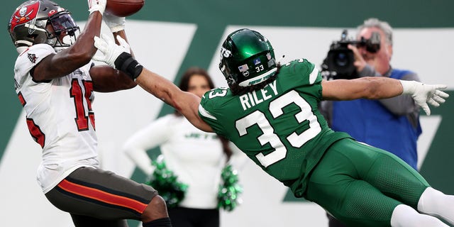Cyril Grayson #15 of the Tampa Bay Buccaneers completes a 33-yard catch over    Elijah Riley #33 of the New York Jets for a touchdown in the fourth quarter of the game at MetLife Stadium on January 02, 2022 in East Rutherford, New Jersey. 