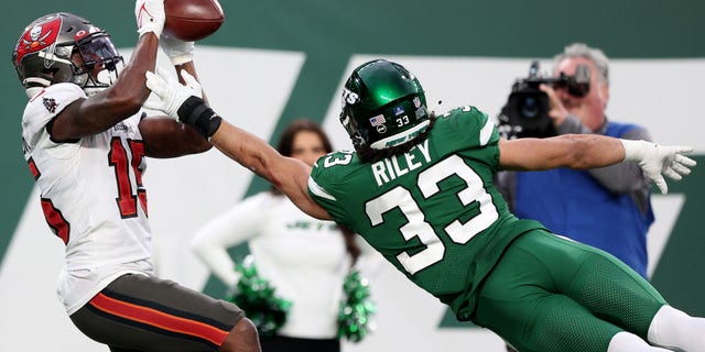 Cyril Grayson #15 of the Tampa Bay Buccaneers completes a 33-yard catch over Elijah Riley #33 of the New York Jets for a touchdown in the fourth quarter of the game at MetLife Stadium on Jan. 2, 2022 位于东卢瑟福, 新泽西州.