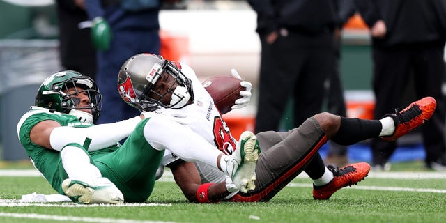 Antonio Brown #81 of the Tampa Bay Buccaneers completes a first down over Bryce Hall #37 of the New York Jets in the third quarter of the game at MetLife Stadium on January 02, 2022 in East Rutherford, New Jersey.