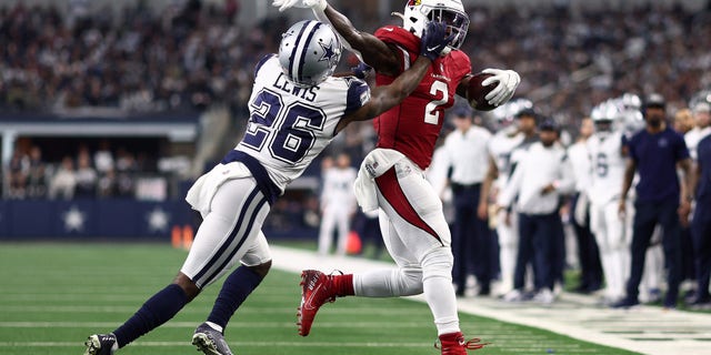Chase Edmonds of the Arizona Cardinals runs the ball and looks to break a tackle by Jourdan Lewis of the Dallas Cowboys on Jan. 2, 2022 in Arlington, Texas.