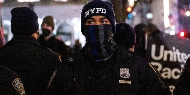 A member of the NYPD wearing a 'back the blue' face mask stands outside of St. Patrick’s Cathedral on January 6, 2022 in New York City.