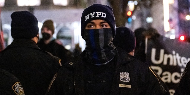 A member of the NYPD wearing a 'back the blue' face mask stands outside of St. Patrick’s Cathedral on January 6, 2022 in New York City.