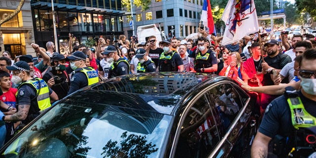 A car believed to be carrying Djokovic leaves Collins Street surrounded by Serbian tennis fans on Jan. 10, 2022 in Melbourne, Australia.