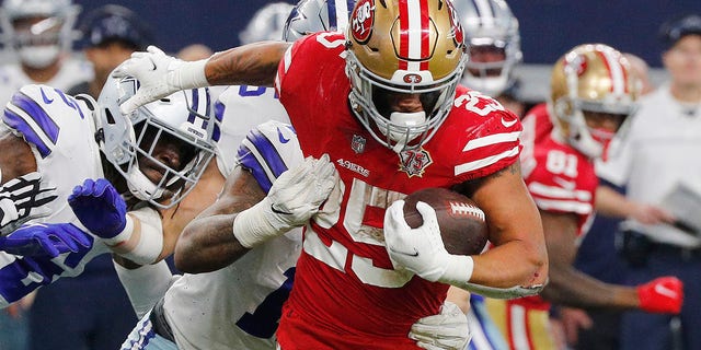 Elijah Mitchell de los San Francisco 49ers lleva el balón contra los Dallas Cowboys # 25 durante el segundo cuarto del juego NFC Wild Card Playoff el 16 de enero de 2023 en el estadio AT&T en Arlington, Texas.