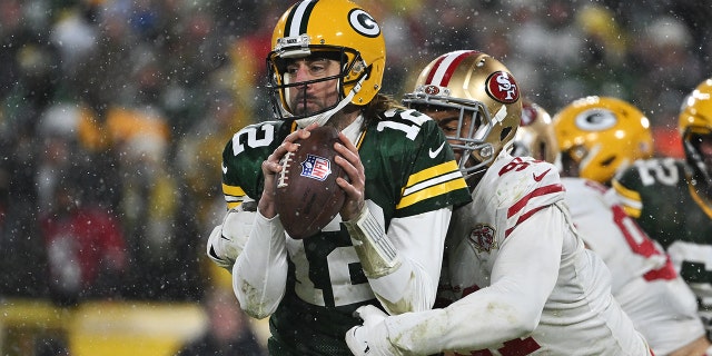 GREEN BAY, WISCONSIN - GENNAIO 22: Quarterback Aaron Rodgers #12 of the Green Bay Packers is sacked by defensive end Arik Armstead #91of the San Francisco 49ers during the 2nd quarter of the NFC Divisional Playoff game against the San Francisco 49ers at Lambeau Field on January 22, 2022 a Green Bay, Wisconsin.