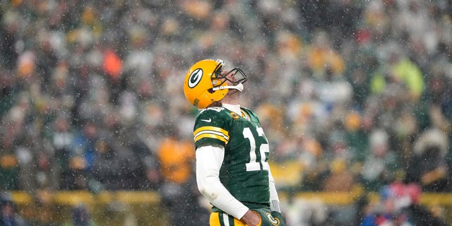 12-й квотербек Аарон Роджерс из Green Bay Packers смотрит в небо во время четвертой четверти игры плей-офф NFC против San Francisco 49ers на стадионе Lambeau Field 22 января 2022 года в Грин-Бей, штат Висконсин. 
