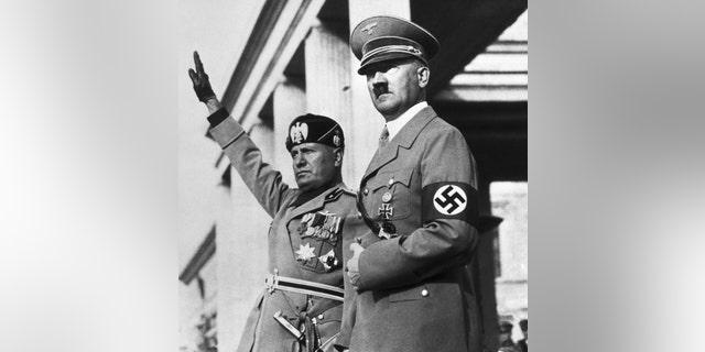 Benito Mussolini and Adolf Hitler watch a Nazi parade staged for the Italian dictators's visit to Germany.