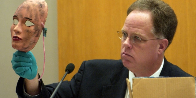 Retail Wichita Police Officer Sam Houston shows off a mask used in one of the crimes during the sentencing hearing for Dennis L. Rader on August 18, 2005, in Wichita, Kan.