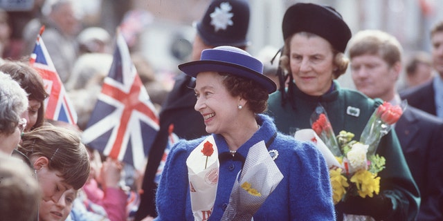 The Queen with the Duchess Of Grafton standing behind.