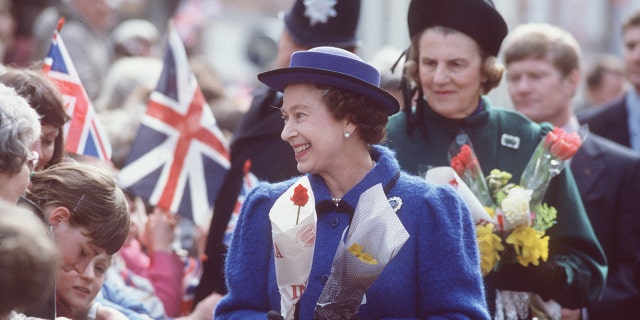 The Queen with the Duchess Of Grafton standing behind.