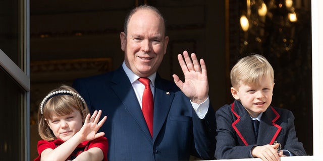 Princess Gabriella of Monaco, Prince Albert II of Monaco and Prince Jacques of Monaco greet the crowd from the palace balcony during the Saint Devote Ceremony on January 27, 2022.