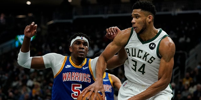 Milwaukee Bucks' Giannis Antetokounmpo drives past Golden State Warriors' Kevon Looney during the second half of an NBA basketball game Thursday, Jan. 13, 2022, in Milwaukee.