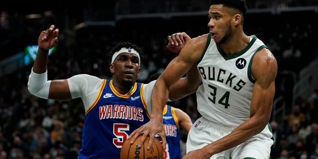 Milwaukee Bucks' Giannis Antetokounmpo drives past Golden State Warriors' Kevon Looney during the second half of an NBA basketball game Thursday, Jan. 13, 2022, in Milwaukee.