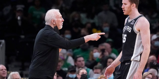 San Antonio Spurs head coach Gregg Popovich gestures towards San Antonio Spurs center Jakob Poeltl (25) during the first half of an NBA basketball game, Wednesday, Jan. 5, 2022, in Boston.