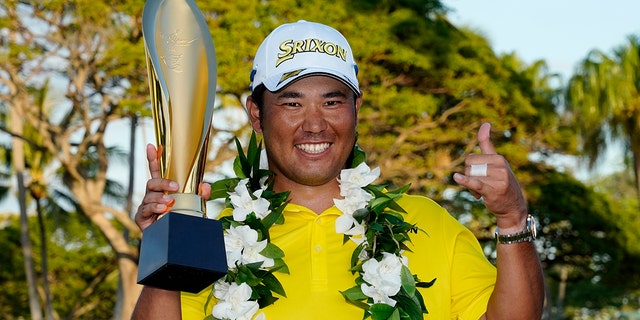 Hideki Matsuyama, of Japan, holds the champions trophy after the final round of the Sony Open golf tournament, Domenica, Jan. 16, 2022, at Waialae Country Club in Honolulu.