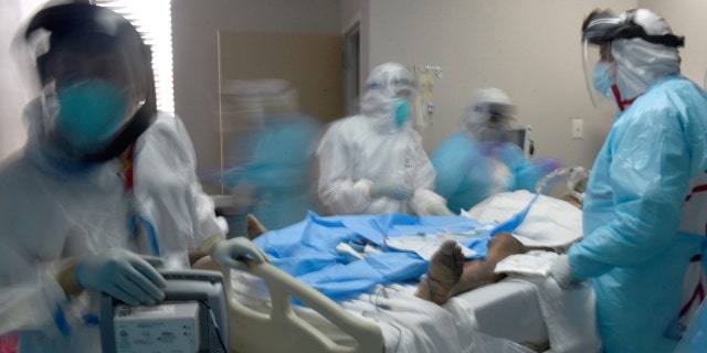 Healthcare workers treat a patient infected with the coronavirus disease (COVID-19) at United Memorial Medical Center in Houston, Texas, U.S., December 29, 2020.