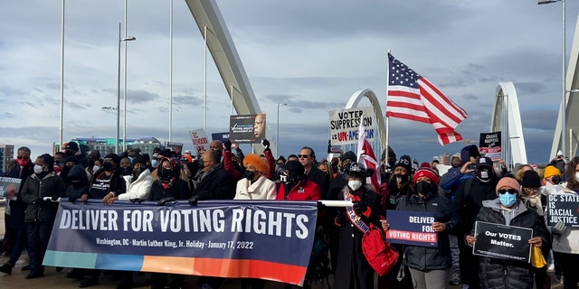 Marchers hold 'Deliver for Voting Rights' sign