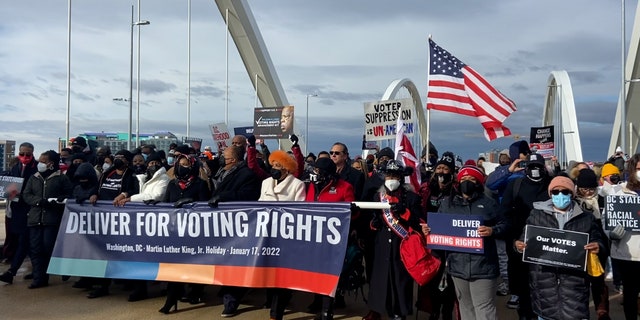 Marchers hold 'Deliver for Voting Rights' sign