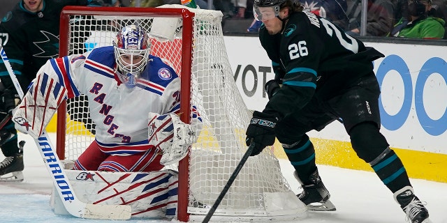 New York Rangers goaltender Igor Shesterkin, left, defends a shot attempt against San Jose Sharks center Jasper Weatherby (26) during the first period of an NHL hockey game in San Jose, Calif., Thursday, Jan. 13, 2022.