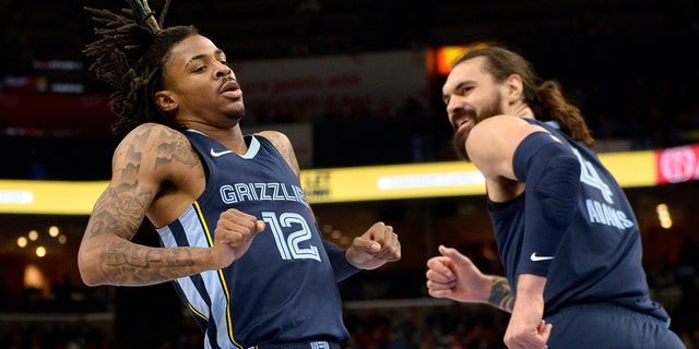 Memphis Grizzlies guard Ja Morant (12) and center Steven Adams (4) react after Morant scored in the first half of an NBA basketball game against the Washington Wizards, Saturday, Jan. 29, 2022, in Memphis, Tenn.
