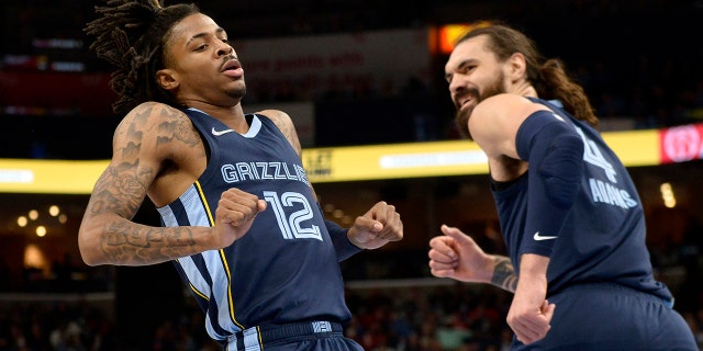 Memphis Grizzlies guard Ja Morant (12) and center Steven Adams (4) react after Morant scored in the first half of an NBA basketball game against the Washington Wizards, Saturday, Jan. 29, 2022, in Memphis, Tenn.