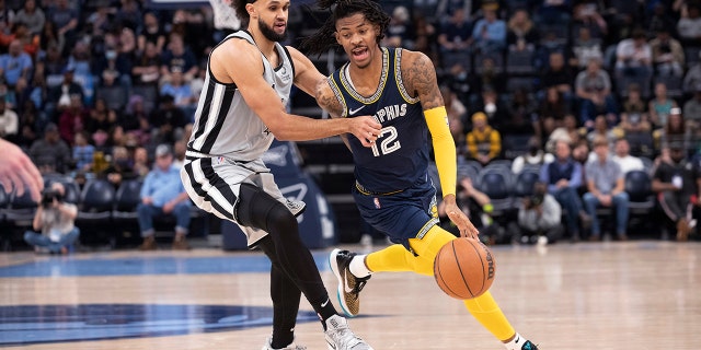San Antonio Spurs guard Derrick White (4) defends against Memphis Grizzlies guard Ja Morant (12) during the second half of an NBA basketball game Friday, Dec. 31, 2021, in Memphis, Tenn.