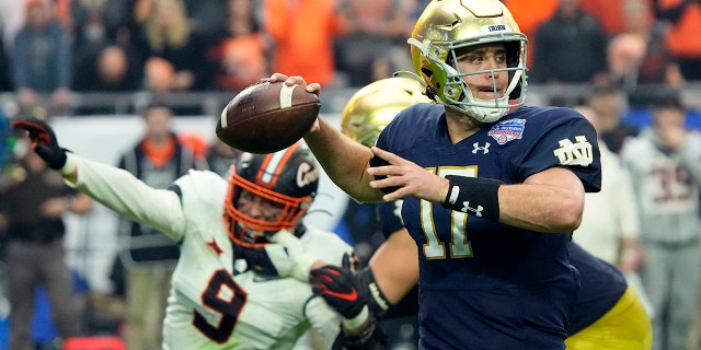 O quarterback do Notre Dame, Jack Kwan (17), joga no lado defensivo do Estado de Oklahoma, Brock Martin (9), durante a segunda metade do Fiesta Bowl no sábado, 1º de janeiro de 2022, em Glendale, Arizona.