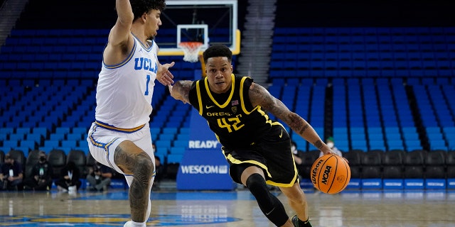 UCLA guard Jules Bernard (1) defends against Oregon guard Jacob Young (42) during the second half of an NCAA college basketball game in Los Angeles, Thursday, Jan. 13, 2022.
