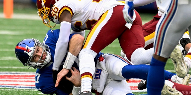 New York Giants quarterback Jake Fromm (17) is sacked by Washington Football Team cornerback Danny Johnson during the first quarter Saturday, 1 월. 9, 2021, 이스트 러더퍼드에서, N.J.