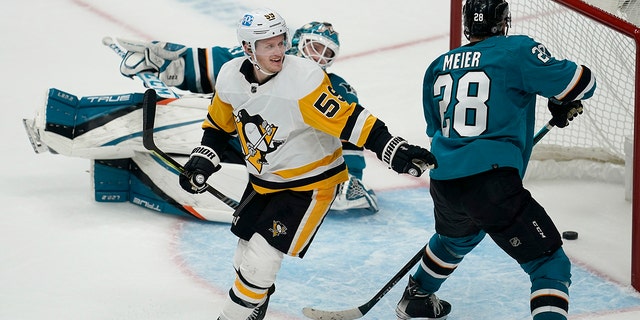 Pittsburgh Penguins left wing Jake Guentzel, 左, celebrates after scoring in front of San Jose Sharks goaltender Adin Hill, rear, and right wing Timo Meier (28) during overtime of an NHL hockey game in San Jose, カリフォルニア, 土曜日, 1月. 15, 2022. The Penguins won 2-1.