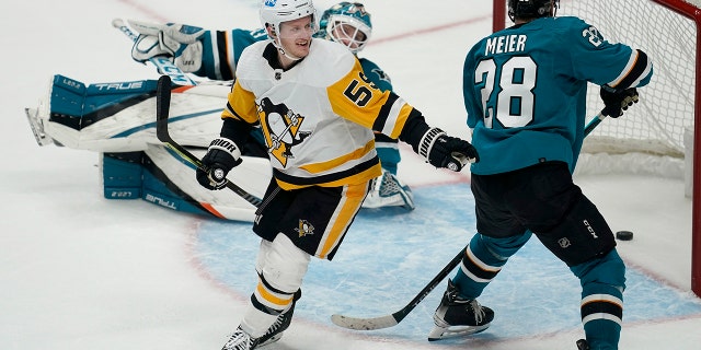 Pittsburgh Penguins left wing Jake Guentzel, 左, celebrates after scoring in front of San Jose Sharks goaltender Adin Hill, rear, and right wing Timo Meier (28) during overtime of an NHL hockey game in San Jose, カリフォルニア, 土曜日, 1月. 15, 2022. The Penguins won 2-1.