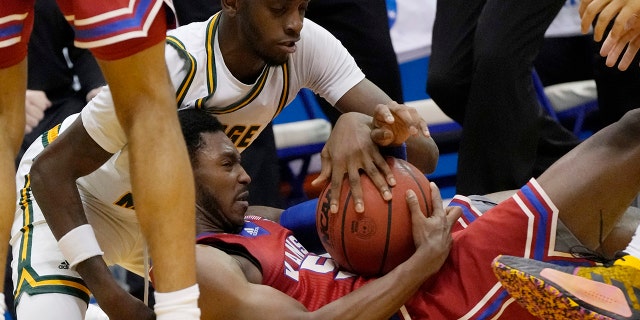Kansas guard Jalen Coleman-Lands (55) hits the floor with George Mason guard Davonte Gaines, left, during the second half of an NCAA college basketball game in Lawrence, Kan., Saturday, Jan. 1, 2022. Kansas defeated George Mason 76-67.