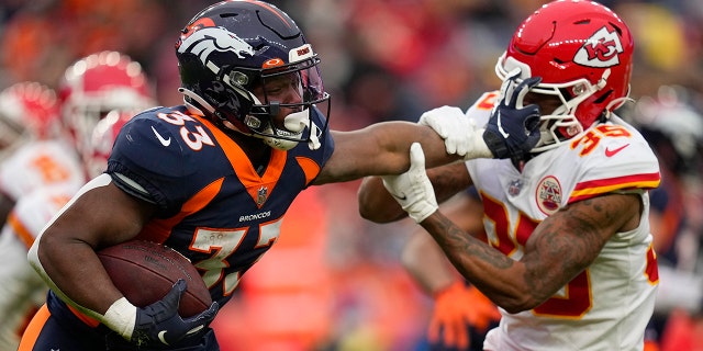Broncos running back Javonte Williams runs against Kansas City Chiefs cornerback Charvarius Ward on Jan. 8, 2022, in Denver.
