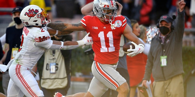 Ohio State wide receiver Jaxon Smith-Njigba (11) scores a touchdown past Utah cornerback Kenzel Lawler (2) during the first half in the Rose Bowl NCAA college football game Saturday, Jan. 1, 2022, in Pasadena, Calif.